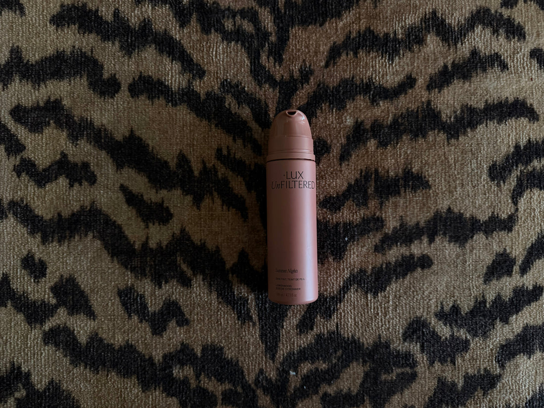 Close-up of LUX Unfiltered Summer Nights skin tint bottle showcasing pink packaging with a black and tan patterned background
