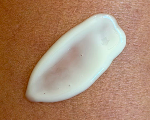 Close-up of Après Sun Tan Extending Serum swatch on skin showcasing lightweight creamy texture and dewy finish