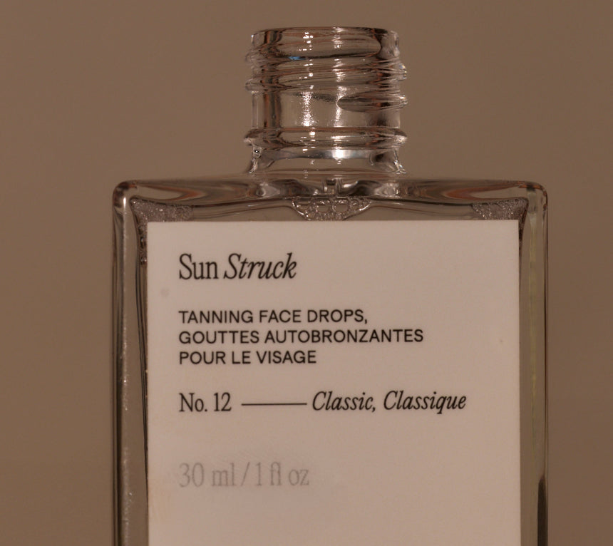 Front view of Sun Struck tanning face drops classic bottle showcasing No. 12 Classic and 30 ml size on brown background