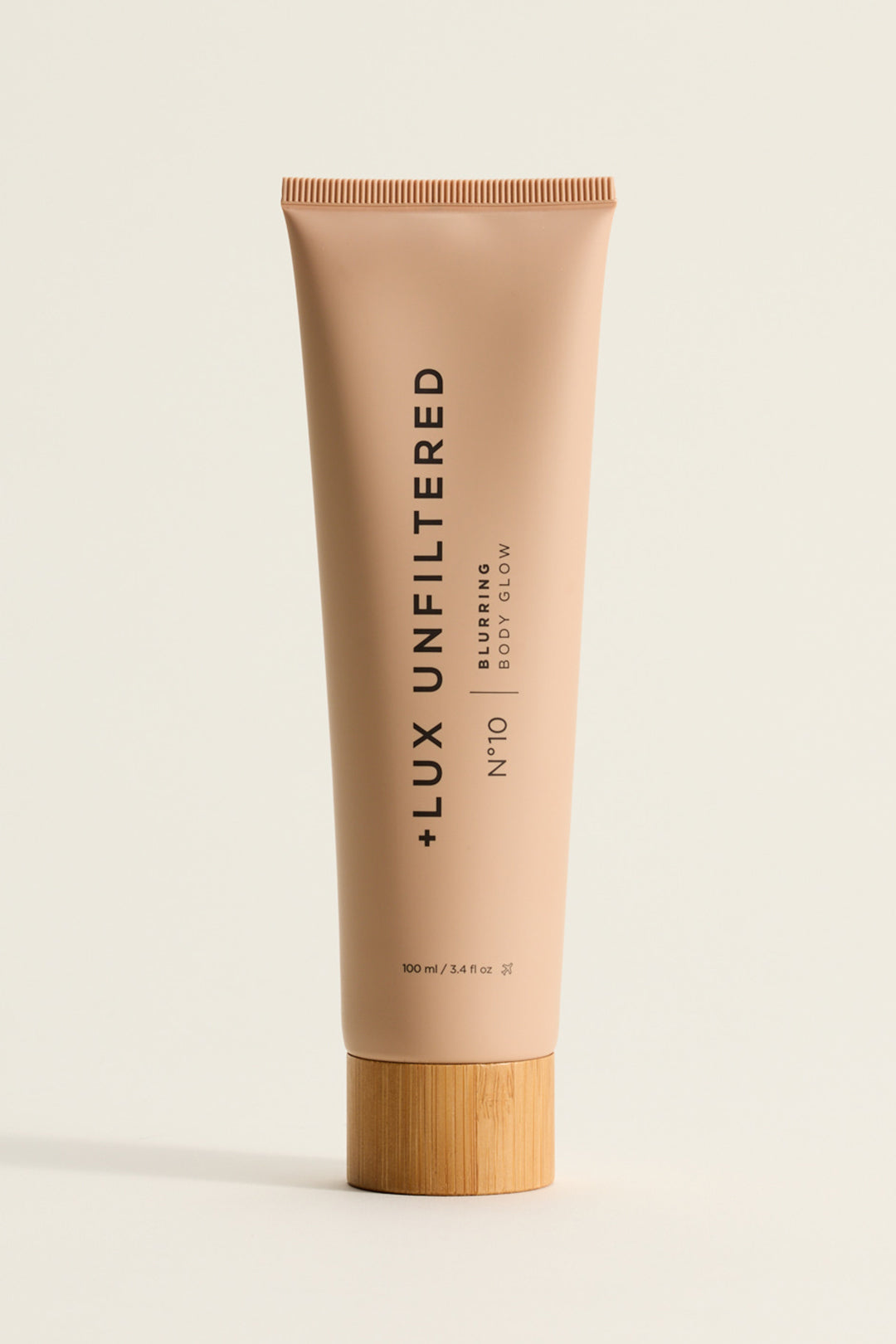 Front view of Golden Era Blurring Body Glow tube No 10 with matte beige finish and bamboo cap on light background